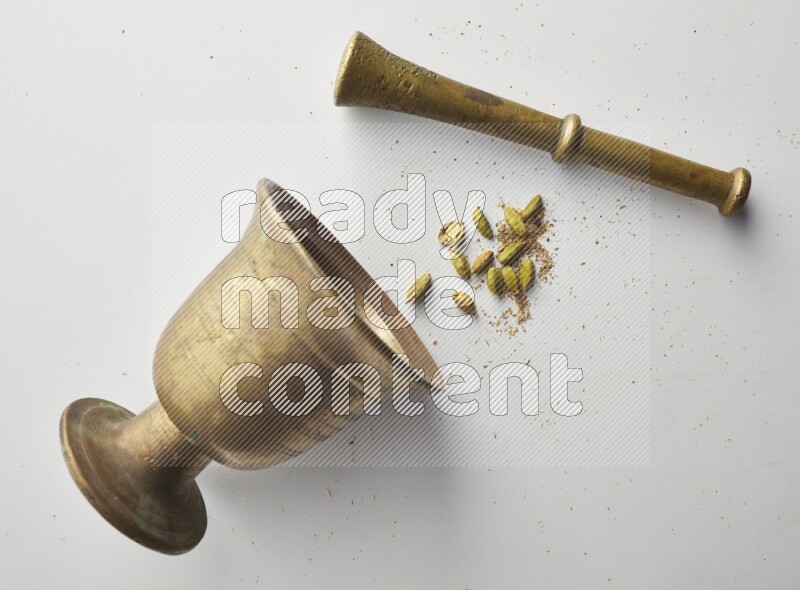 Top-view shot of Cardamon in herbs crusher on white background