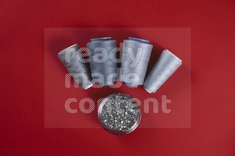 Grey sewing supplies on red background