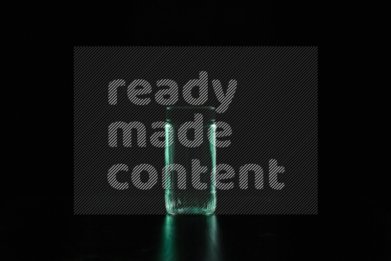 Glassware with rim light in green against black background