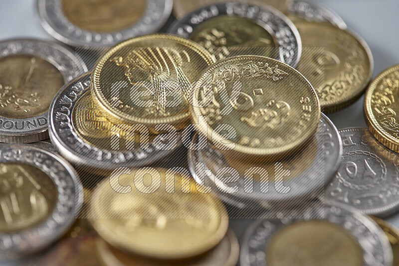 A close-up of scattered mixed Egyptian coins such as One pound, 50 and 25 piasters on grey background