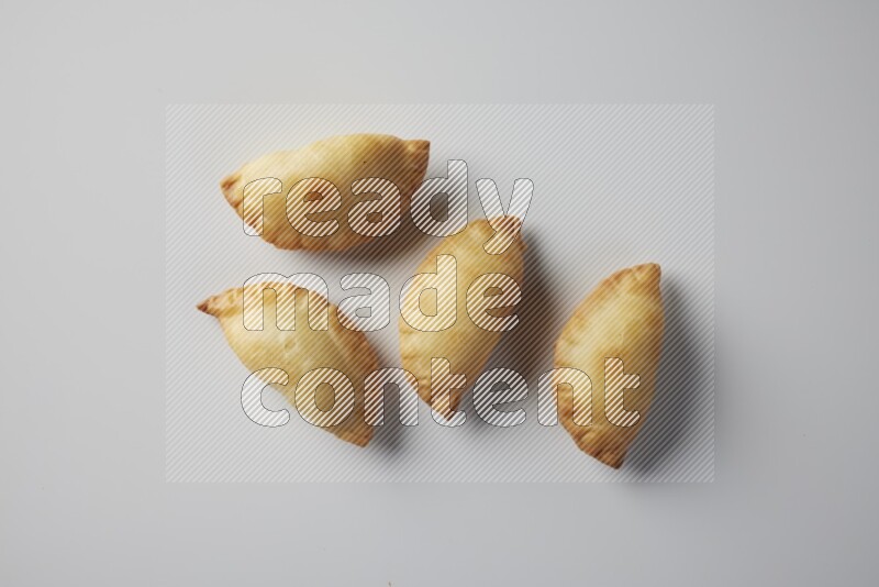 Four fried sambosa from a top angle on a white background