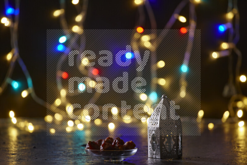 A traditional ramadan lantern surrounded by glowing fairy lights in a dark setup