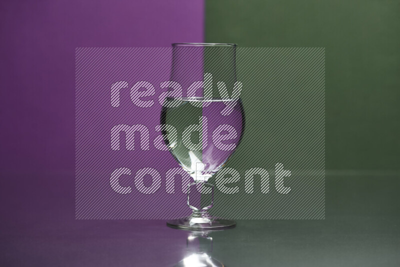 The image features a clear glassware filled with water, set against purple and dark green background