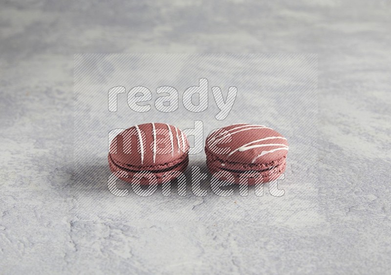45º Shot of two Red Poppy Flower macarons on white  marble background