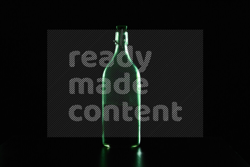 Water bottle with colored rim light against black background