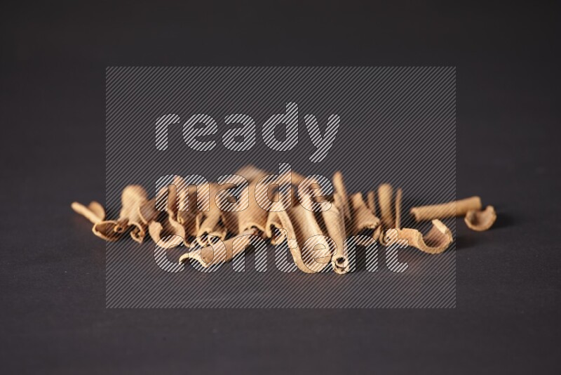 Cracked cinnamon sticks on a black background