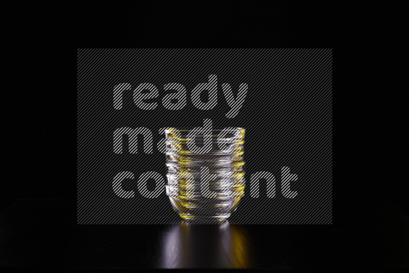 Glassware with rim light in yellow and white against black background