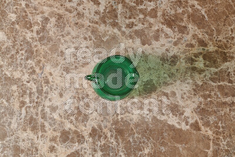 A colored glass jug on beige marble background
