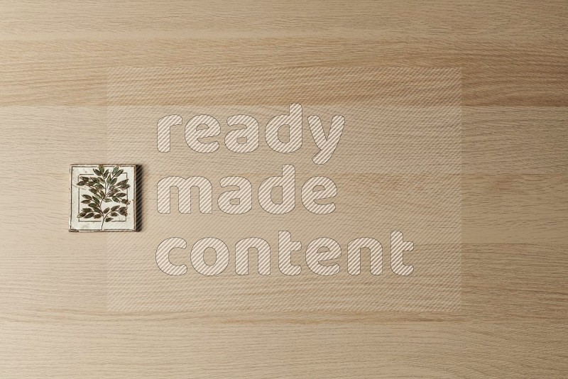Top view shot of a pottery coaster\ tile on oak wooden flooring