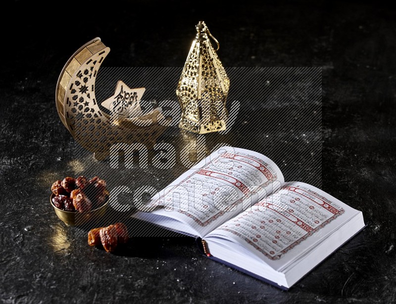 Dates in a metal bowl with quran beside golden lanterns in a dark setup