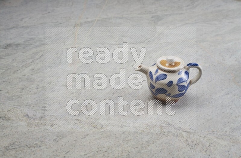 A pottery teapot on grey marble background
