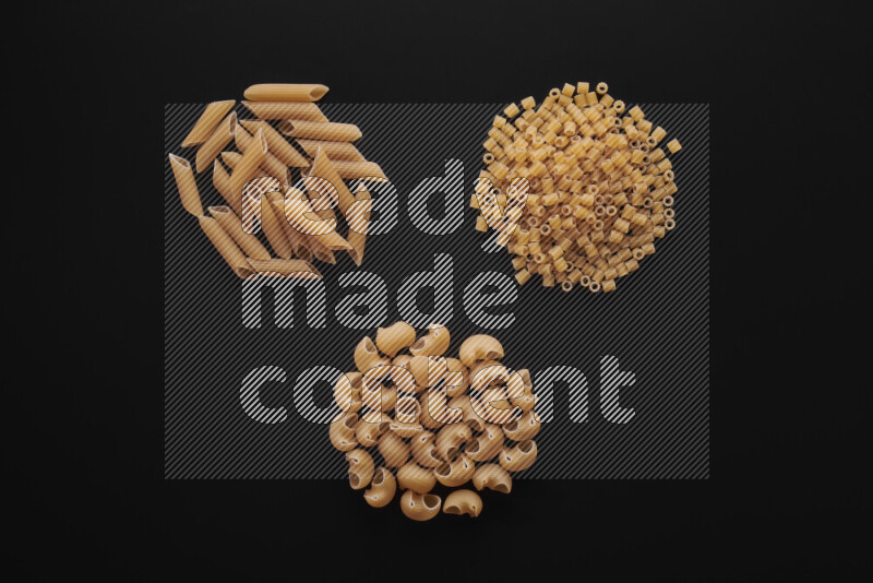 Different pasta types in bunches on black background