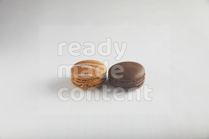 45º Shot of of two assorted Brown Irish Cream, and Brown Dark Chocolate macarons on white background