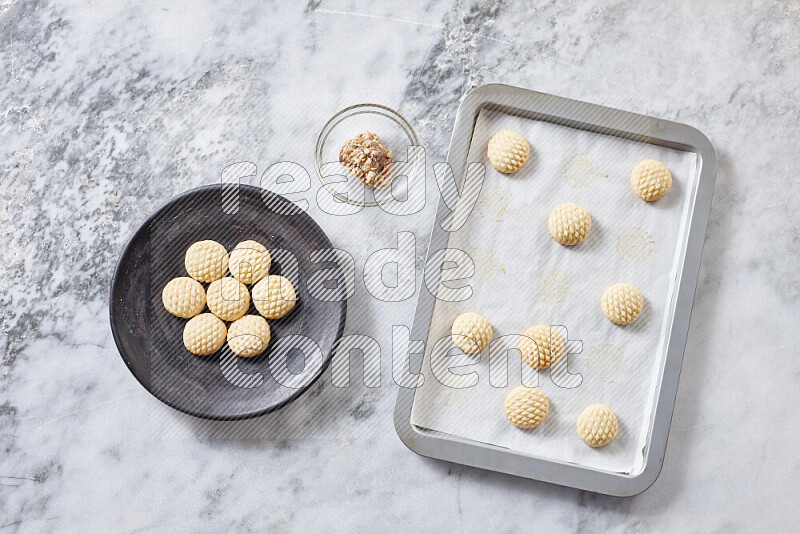 Kahk step by step with its ingredients ghee, sugar, flour, sesame, yeast, water and kahk flavor on grey marble background