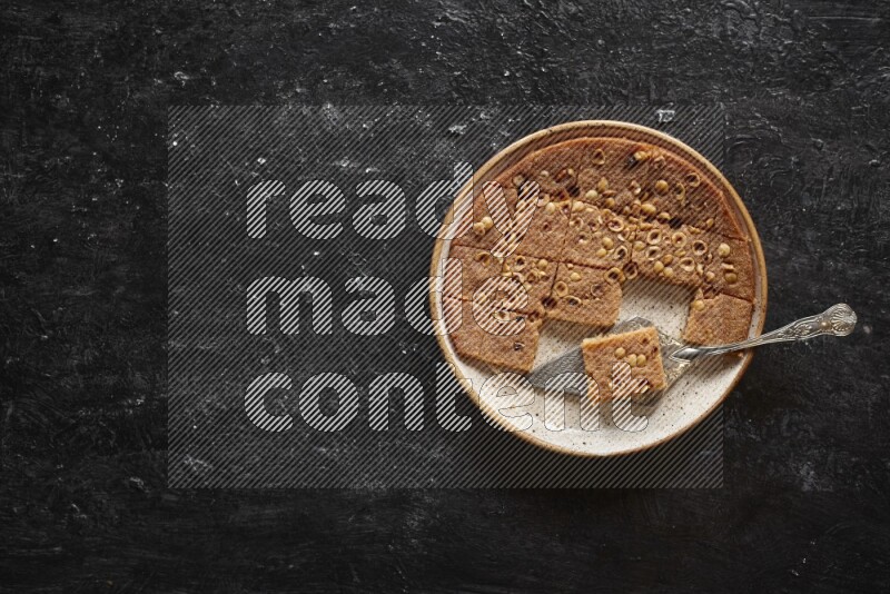 Basbousa in different plates in a dark setup