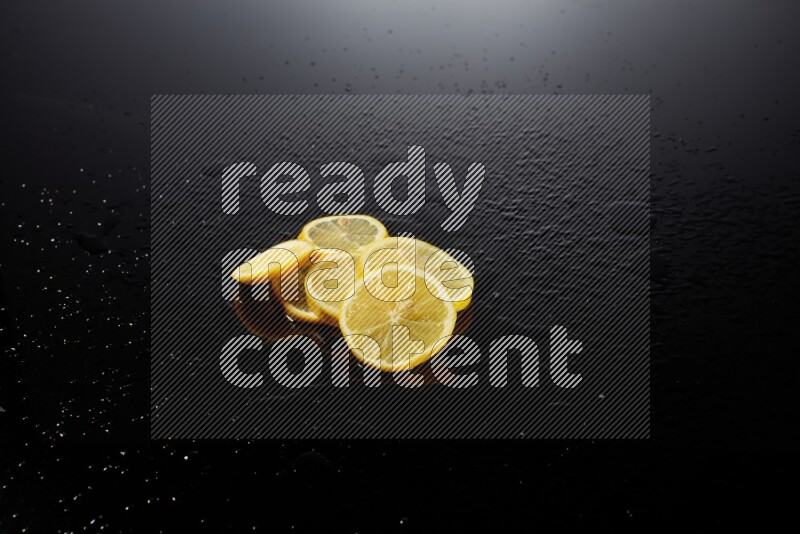 Lemon slices with water drops, and droplets on black background