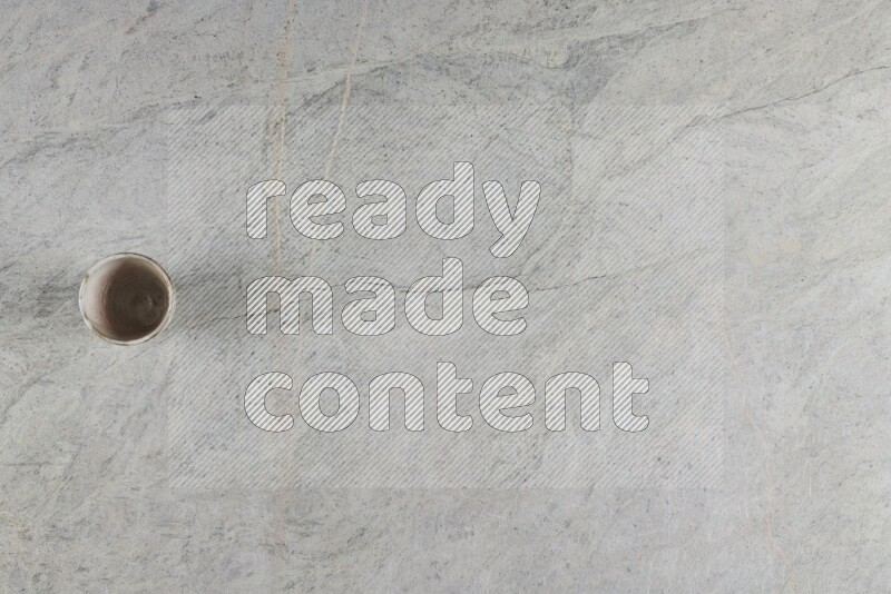 A multicolored pottery Cup on grey marble background