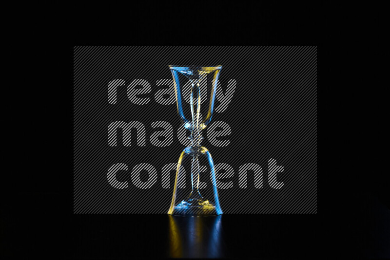 Glassware with rim light in blue and yellow against black background