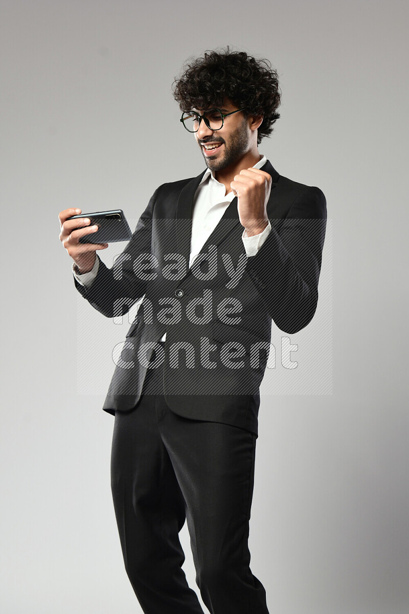 رجل يرتدي ملابس رسمية يلعب علي الهاتف علي خلفية بيضاء