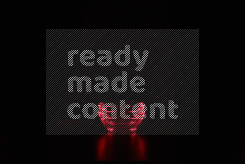 Glassware with rim light in red against black background