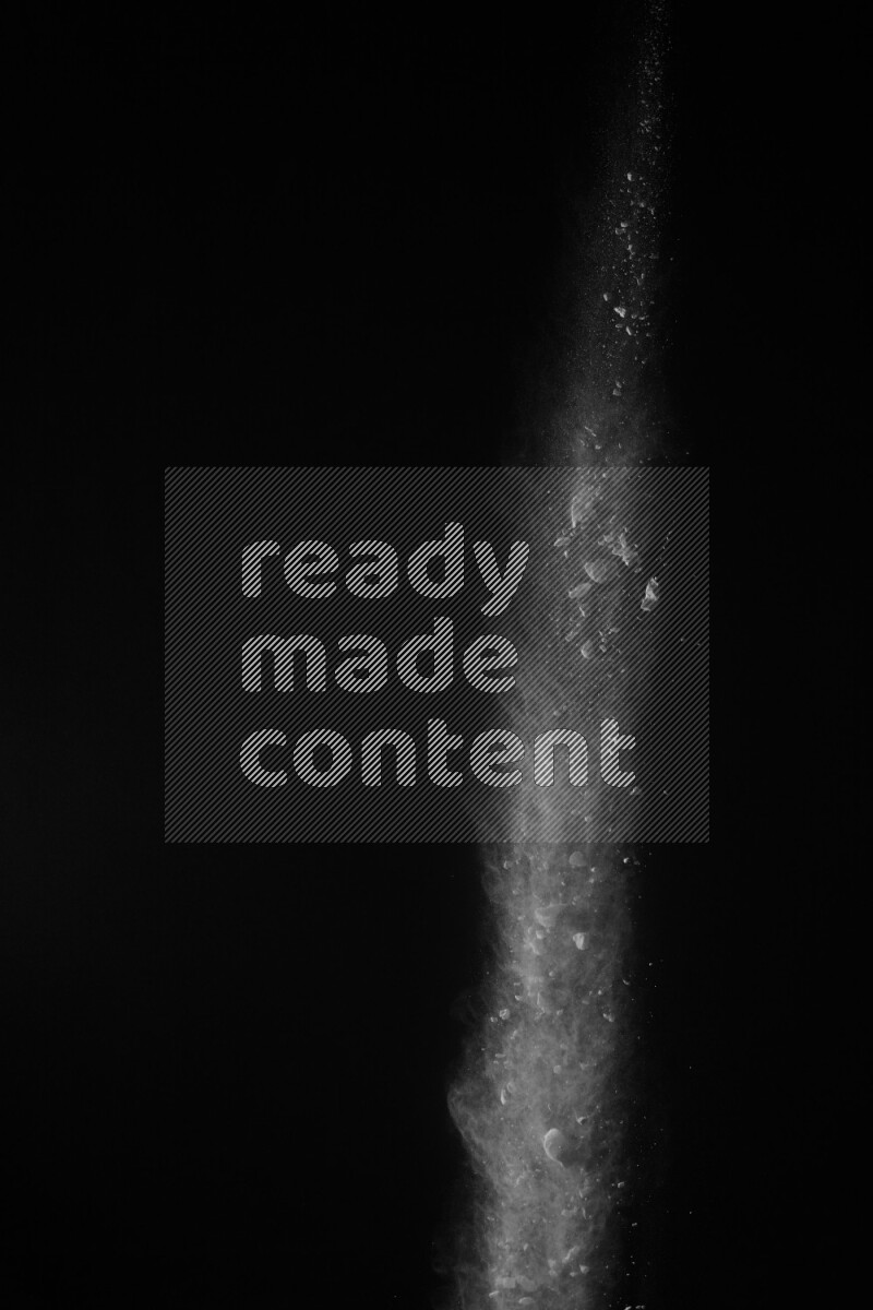 A side view of white powder explosion on black background