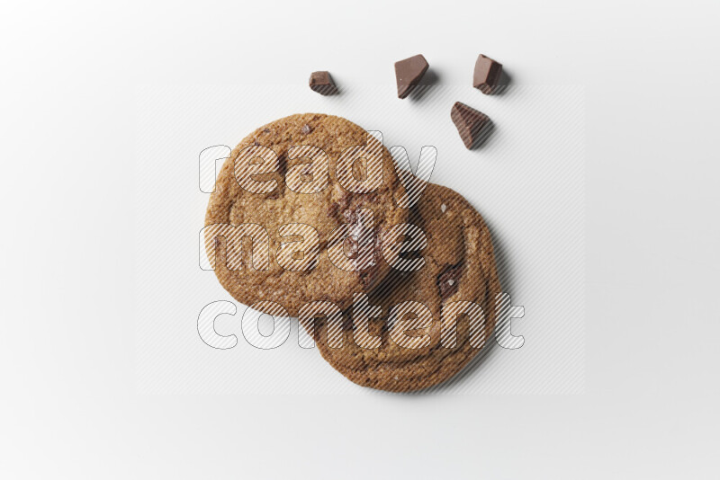 Chocolate chips cookies with chocolate beside it on a white background