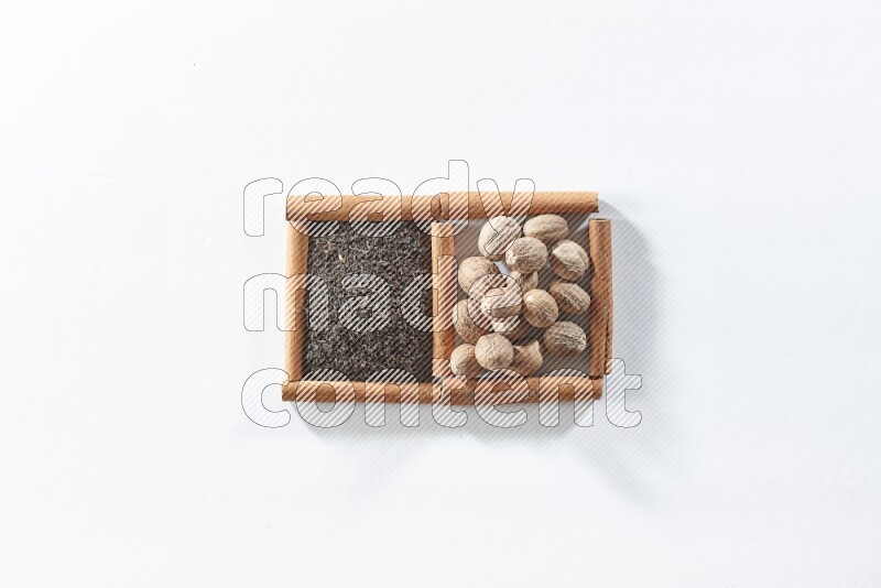 2 squares of cinnamon sticks full of black tea and nutmegs on white flooring
