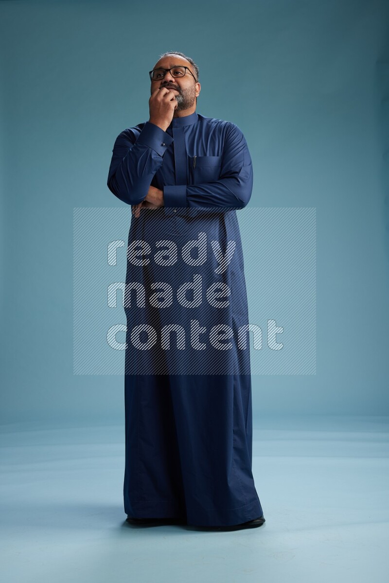 Saudi Man without shimag Standing Interacting with the camera on blue background