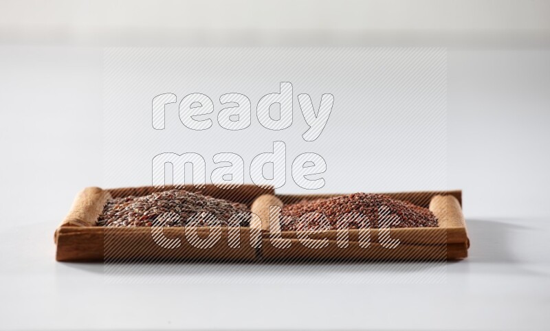 2 squares of cinnamon sticks full of flaxseeds and garden cress on white flooring