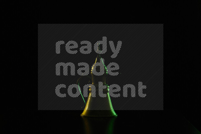 A turkish coffee pot with colored rim light against black background