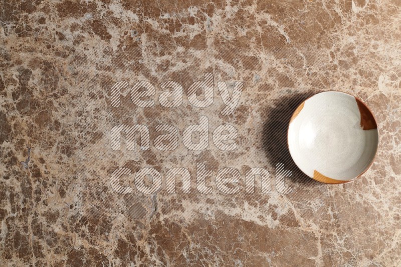 Top View Shot Of A Multicolored Pottery bowl On beige Marble Flooring