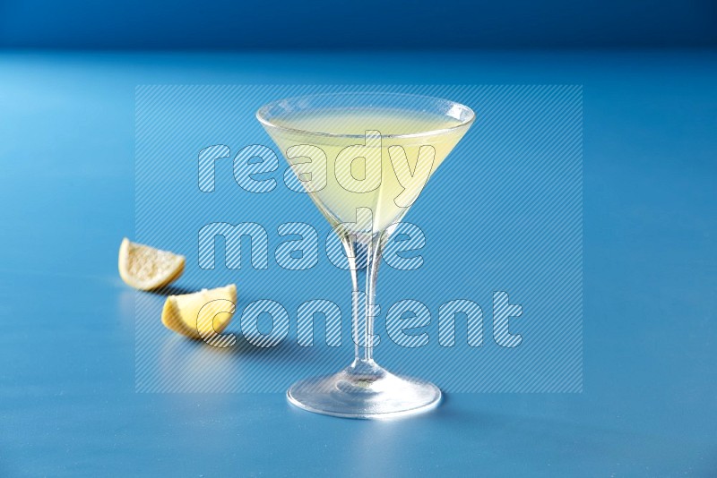 glass of lemon juice on blue background