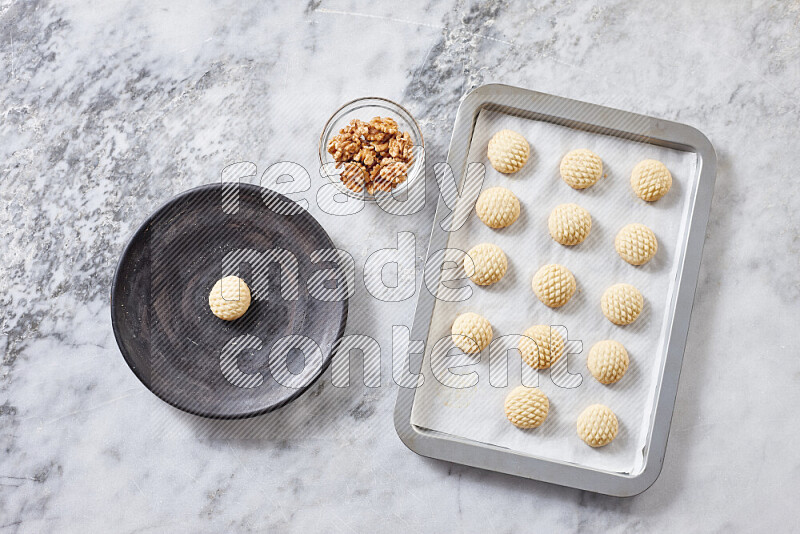 Kahk step by step with its ingredients ghee, sugar, flour, sesame, yeast, water and kahk flavor on grey marble background