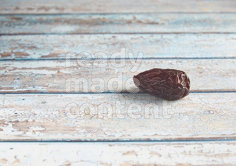 one madjoul date on a light blue wooden background