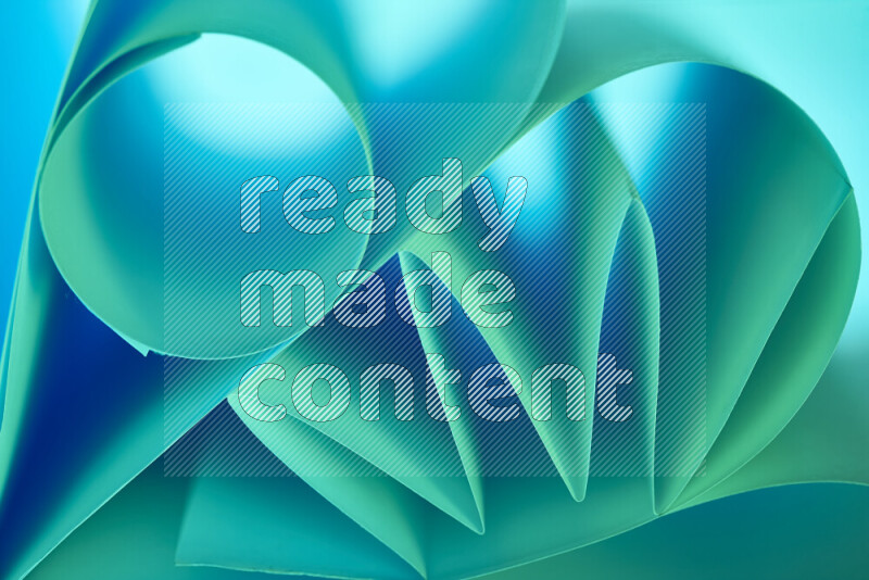 An artistic display of paper folds creating a harmonious blend of geometric shapes, highlighted by soft lighting in green and blue tones