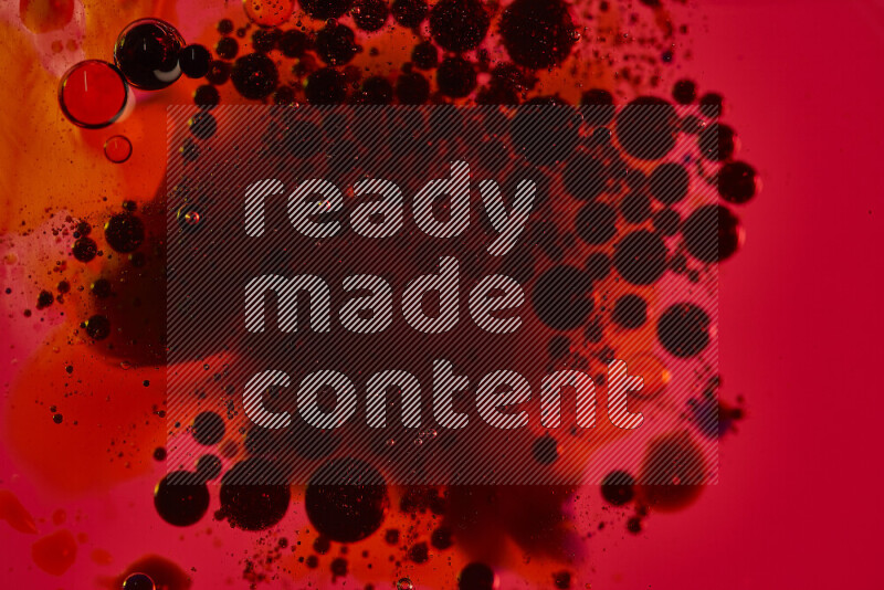 لقطات مقربة لقطرات ألوان مائية سوداء على سطح الزيت على خلفية حمراء