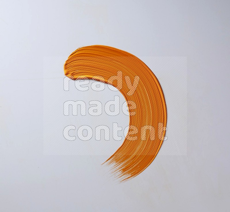 An orange half circular painting brush stroke on white background