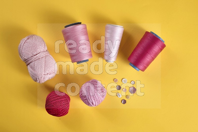 Pink sewing supplies on yellow background