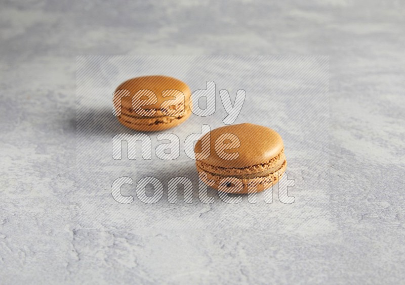 45º Shot of two Brown Maple Taffy macarons  on white  marble background