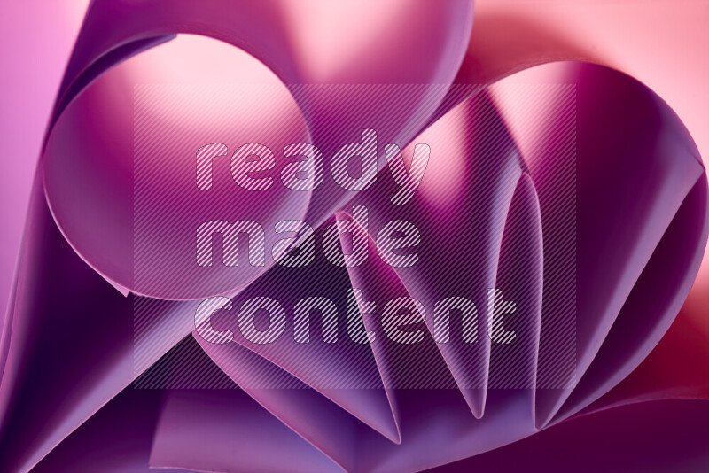 عرض فني لطيات الورق تخلق مزيج من الأشكال الهندسية، مضاءة بإضاءة ناعمة بدرجات اللون الارجواني