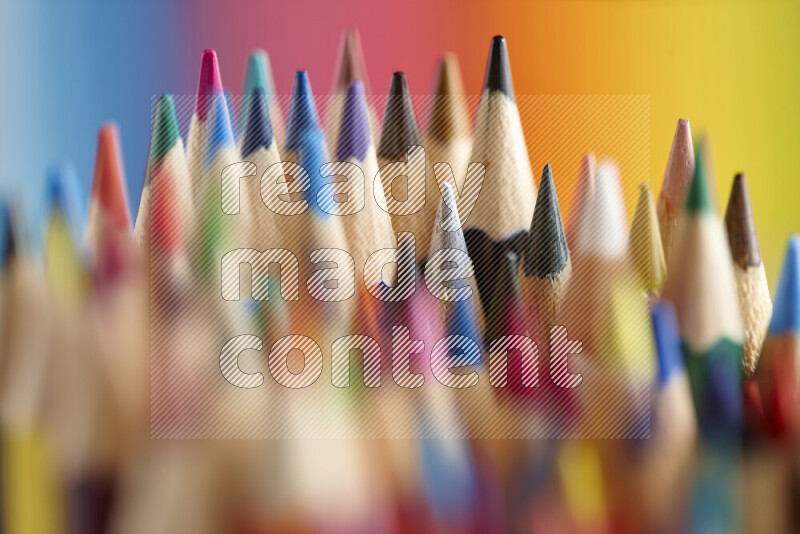 The image captures a close-up of sharpened colored pencils on multicolored background