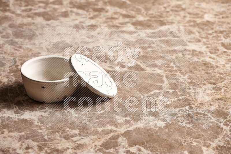 A white pottery bowl on beige marble background