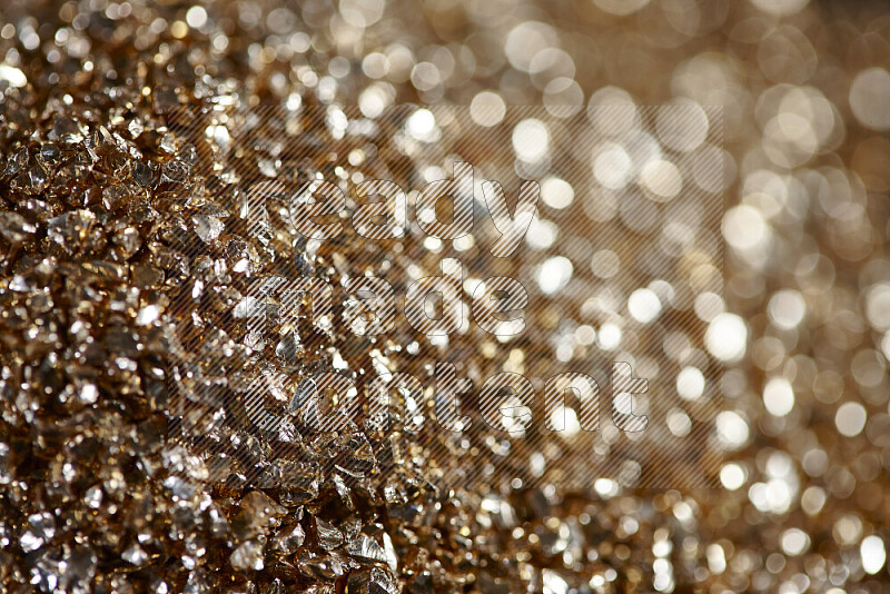 Gold shimmering fragments of glass scattered on a black background