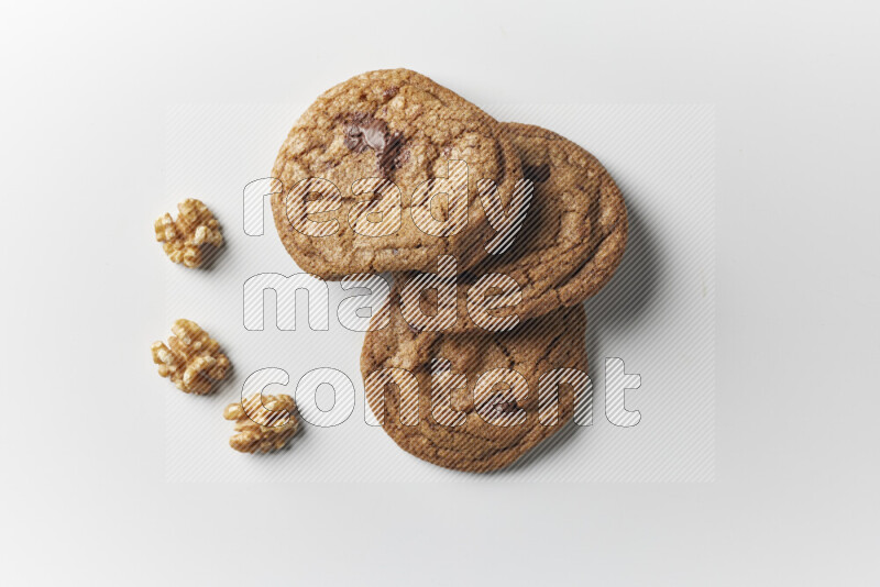 Chocolate chips cookies with walnuts beside it on a white background