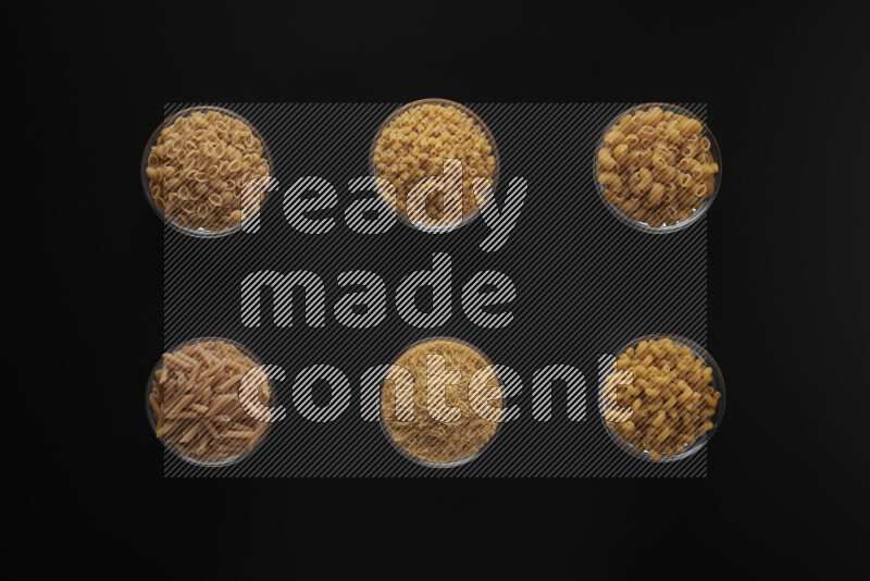 أنواع مختلفة من المعكرونة في أوعية زجاجية علي خلفية سوداء