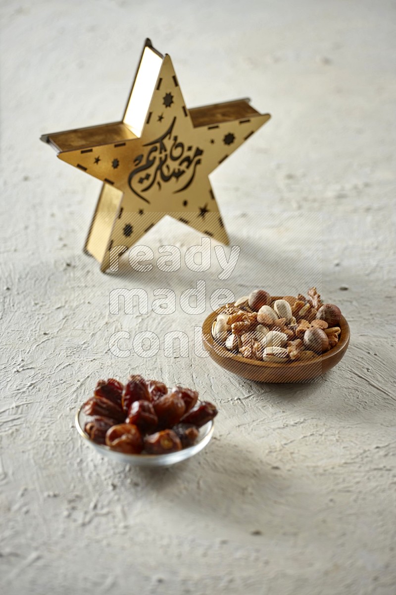 A star lantern with drinks, dates, nuts, prayer beads and quran on textured white background