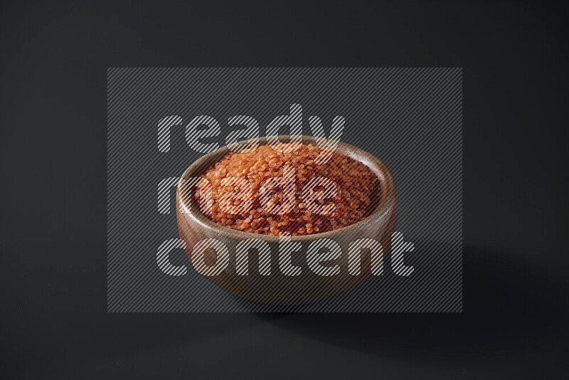 Lentils in a wooden bowl on grey background