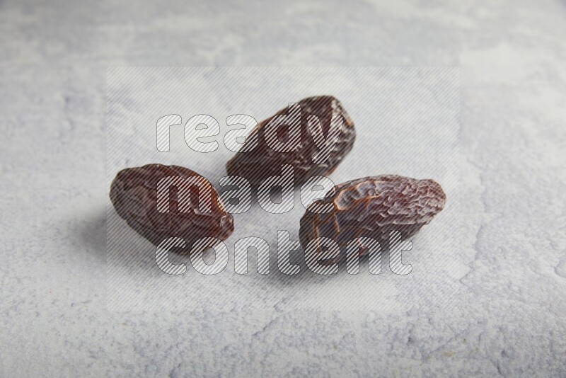 three madjoul dates on a light grey background