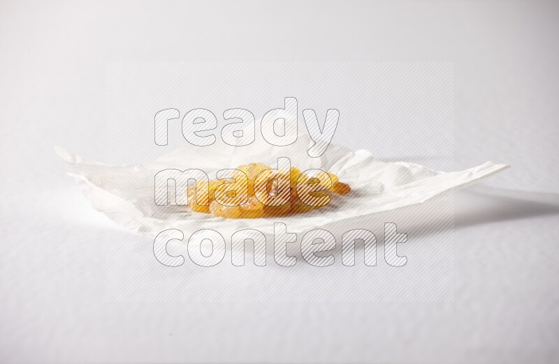 Raisins on a crumpled piece of paper on a white background in different angles