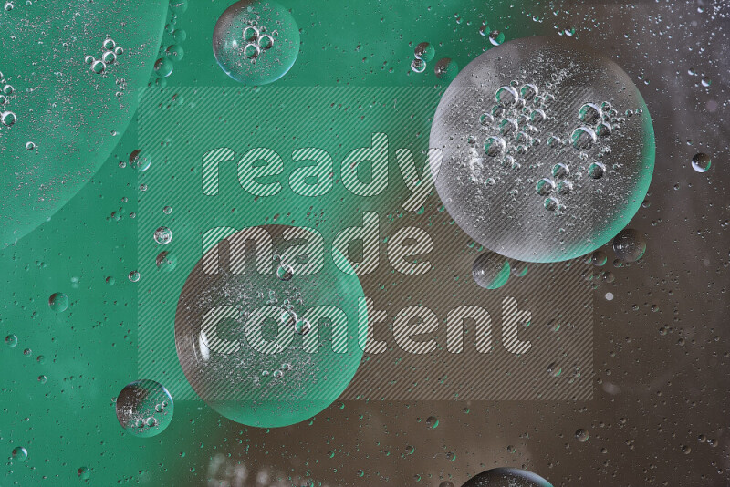 Close-ups of abstract oil bubbles on water surface in shades of green and brown